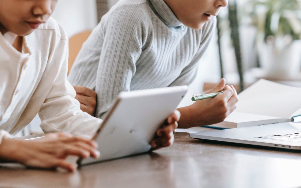 Concentrated children using laptop and tablet at home
