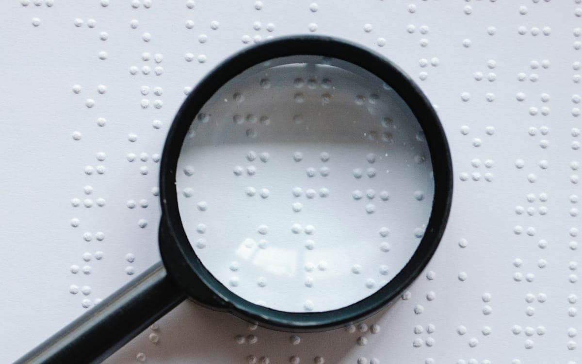 Photo of Magnifying Glass on Top of Braille