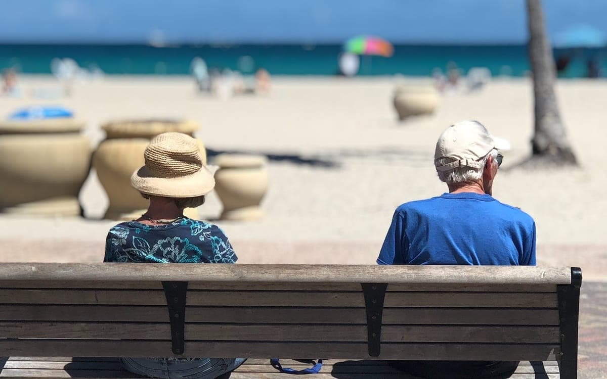 Man and Woman Sitting on Brown Wooden Bench in Hollywood, FL, United States